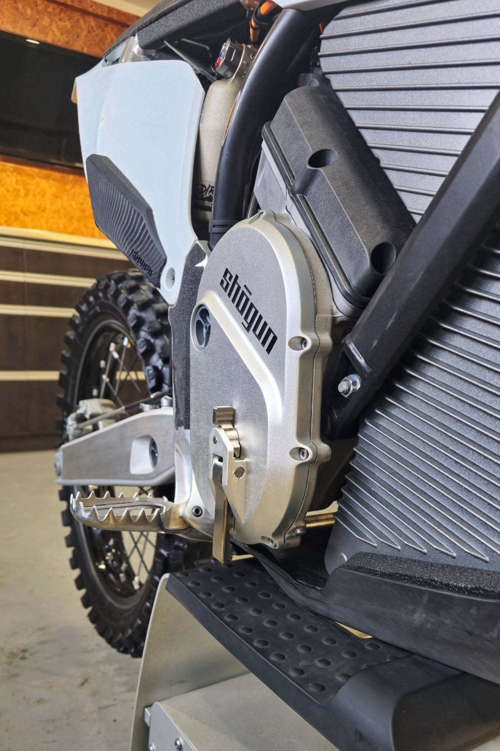 Zoomed-in shot of the right-side Shogun foot hook on a Stark VARG electric motocross bike