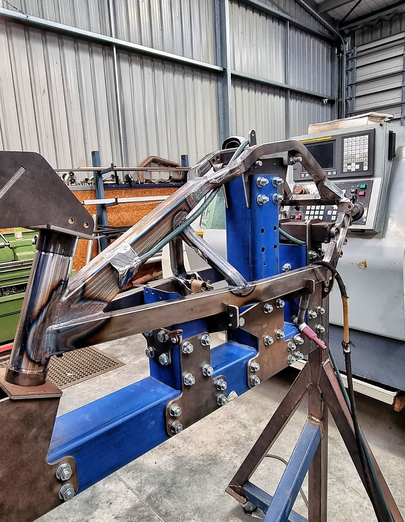 Shogun FMX Bike frame set in a fabrication jig during chassis build and alignment