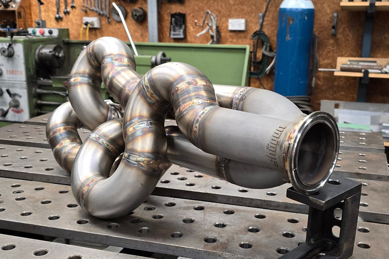 Custom fabricated exhaust header system completed with TIG welded runners, CNC flange and 3D printed collector in a compact design