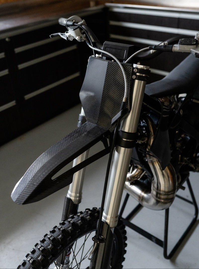 Custom carbon fibre front fender and front number plate fitted to the Shogun FMX Bike showing the lightweight front end design