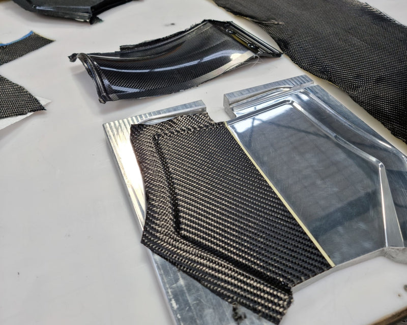 Carbon fiber front number plate being laid up in a billet aluminum mold for the Shogun FMX Bike