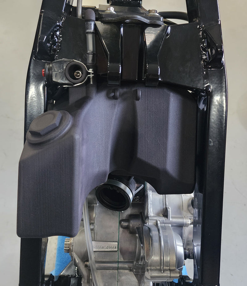 Centrally mounted 3D printed fuel tank integrated into the frame of the Shogun FMX Bike for improved balance and mass centralization