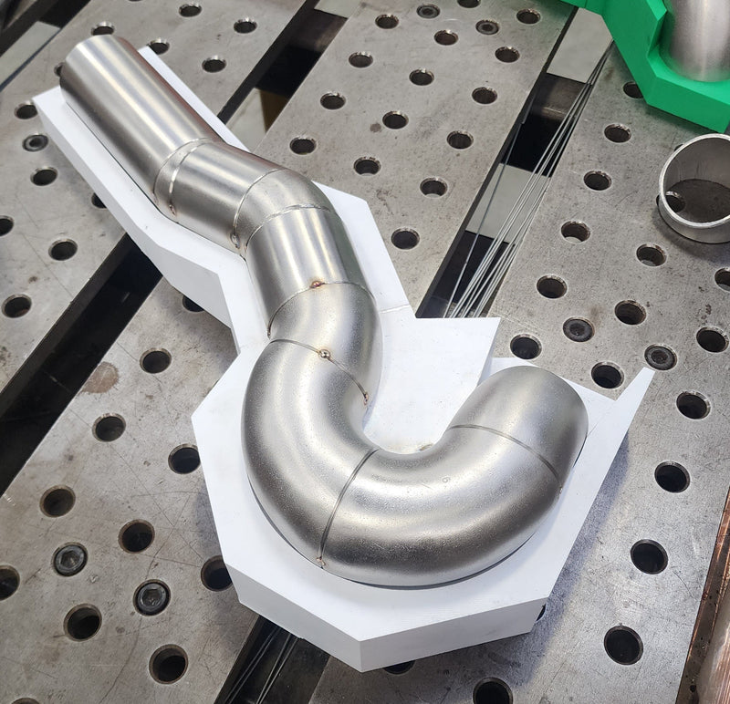 Exhaust header runner tacked in place using 3D printed alignment jig to ensure accuracy and equal length positioning