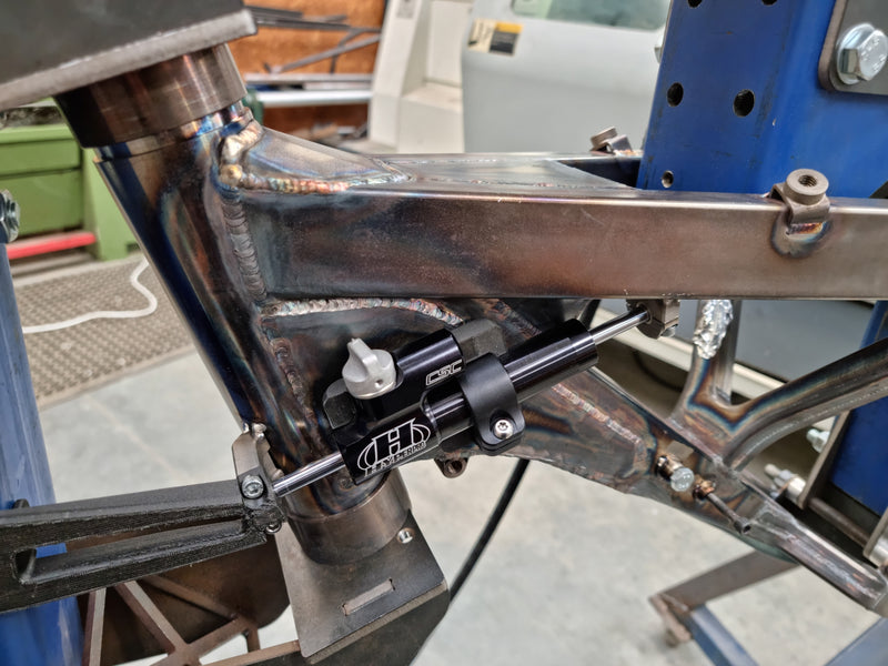 Custom frame in fabrication stage showing the integrated steering damper mount for the Shogun FMX Bike chassis