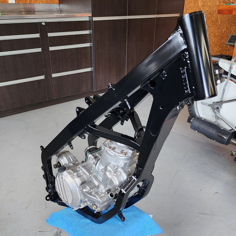 Powder coated Shogun FMX Bike frame and KTM 250 SX engine mounted on a stand during final assembly