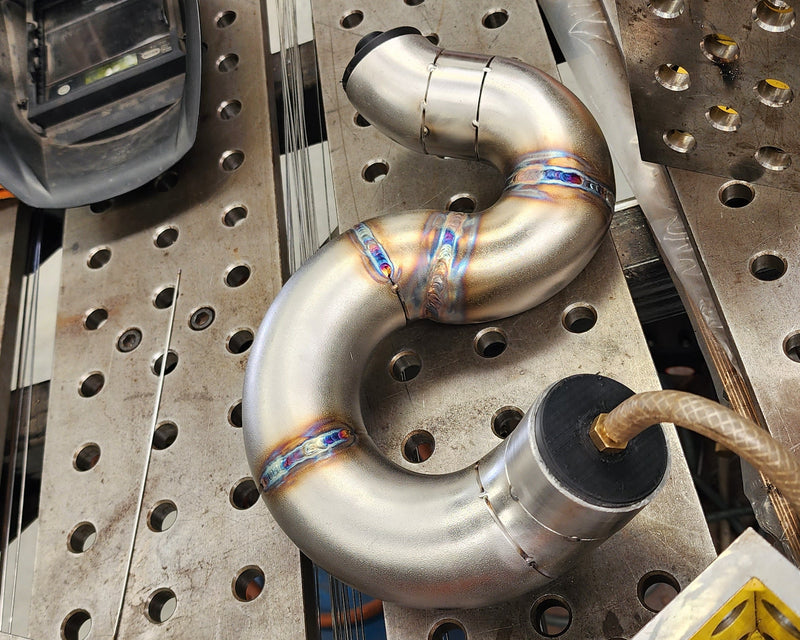 Exhaust header runner being TIG welded with back purging to ensure clean internal welds and optimal flow performance