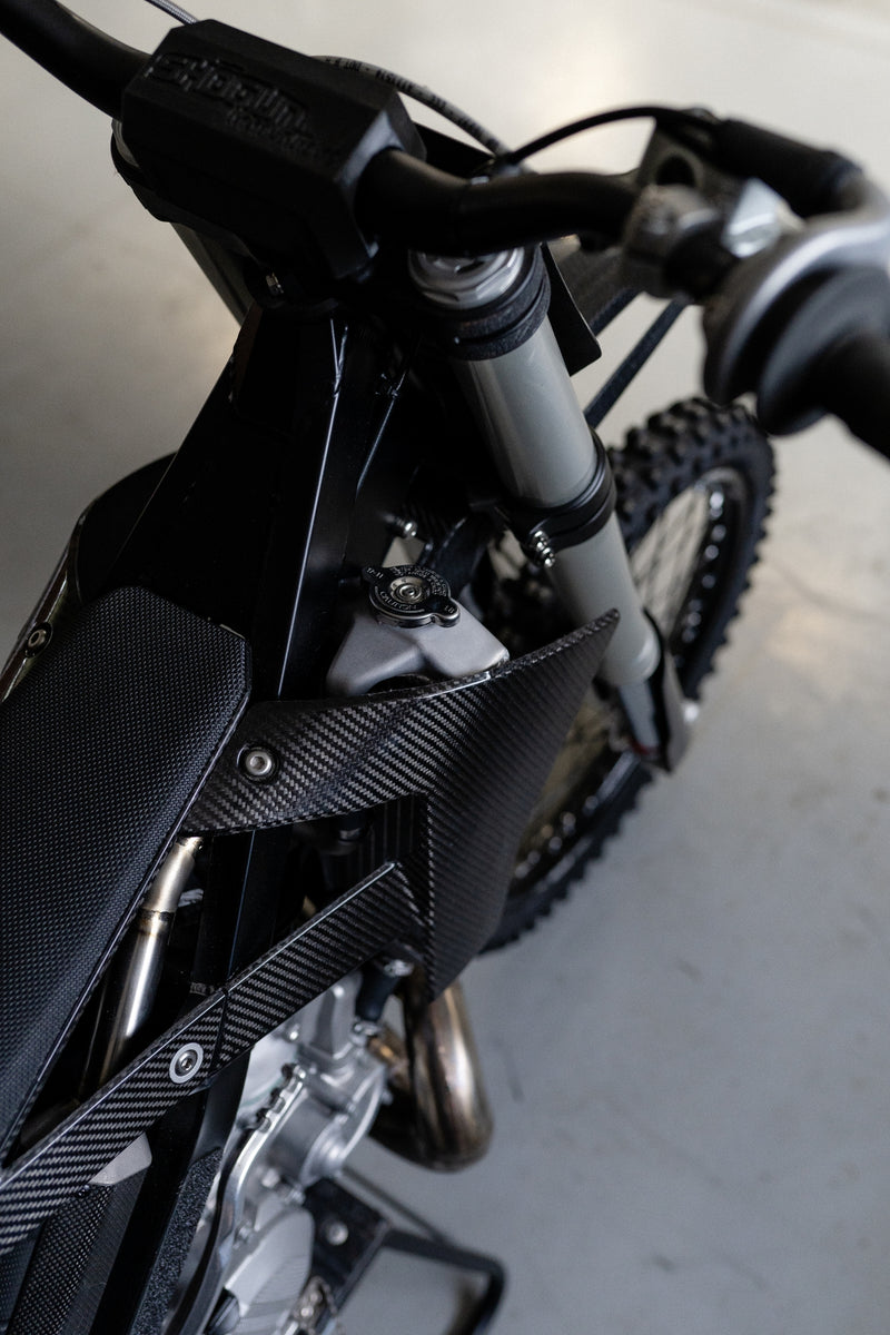 High side angle view of the Shogun FMX Bike showing the carbon fibre shrouds, slim seat, and custom 3D printed radiator components