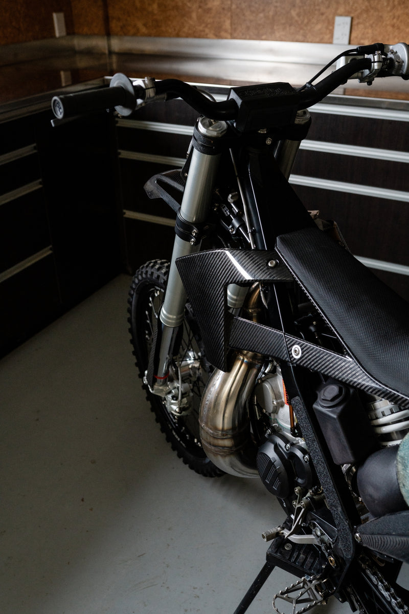 High side angle view of the Shogun FMX Bike showing the carbon fibre shrouds, slim seat, and open bodywork design
