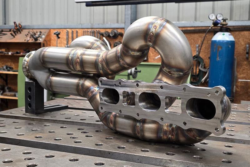 Final turbo exhaust manifold assembly showing equal length runners, precision welding and tight packaging for high performance applications