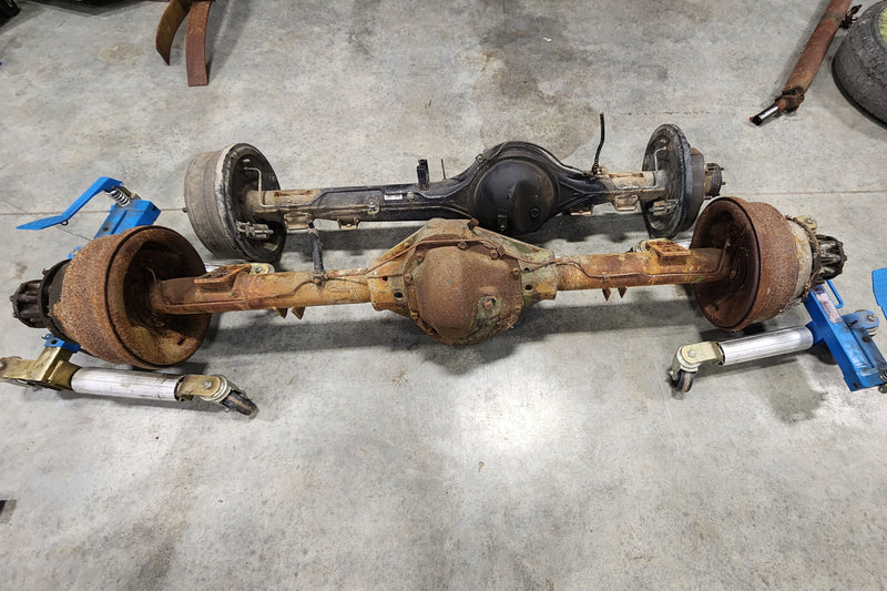 Comparison of factory rear differential next to Dana 70 HD axle prepared for custom vehicle build by Shogun Innovations