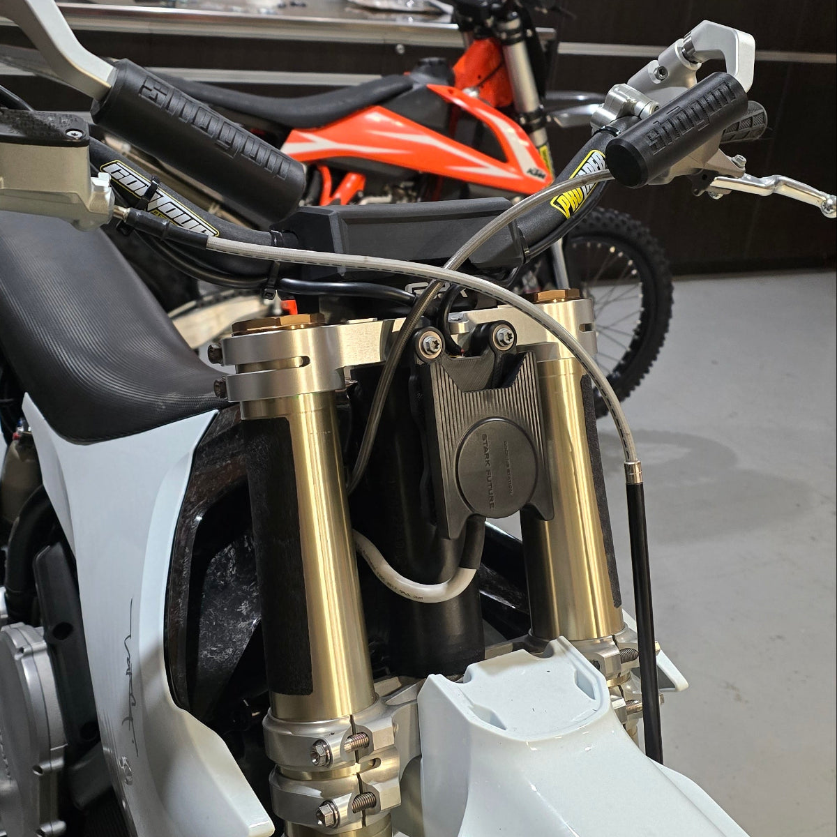 Shogun Stark VARG compatible charger and Bluetooth relocation mount installed on the front of the triple clamp